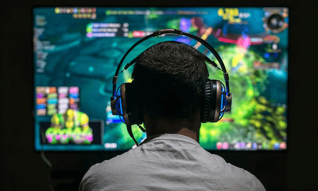 mann som sitter med gamingheadsett og spiller TV-spill